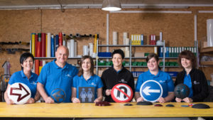 Das Team der Firma Schauppenlehner mit Verkehrsschildern in der Hand
