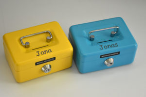 Zwei kleine Geldkassetten in blau und gelb mit den Namen Jana und Jonas graviert