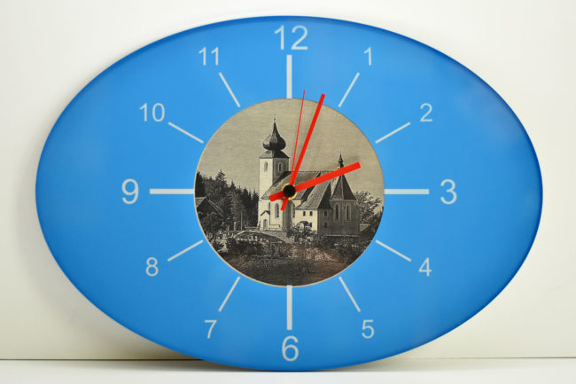 Blaue Wanduhr mit eingraviertem Kirchenmotiv