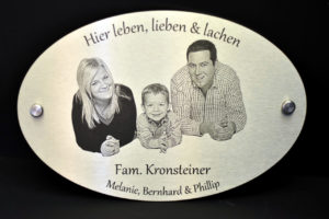 Hausschild mit eingraviertem Familienporträt.